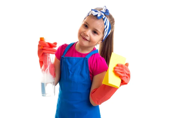 Chica en delantal y guantes sosteniendo spray y plumero — Foto de Stock