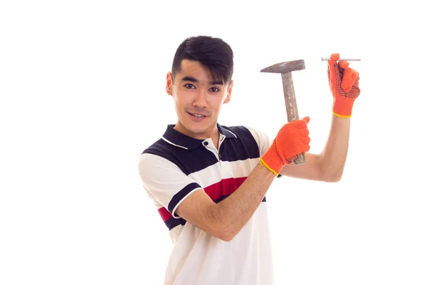 Uomo in guanti arancioni con martello e chiodo — Foto Stock