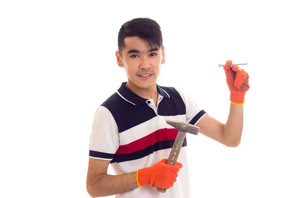 Man in oranje handschoenen holding hamer en spijker — Stockfoto