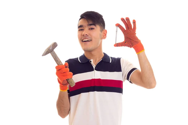 Man in oranje handschoenen holding hamer en spijker — Stockfoto