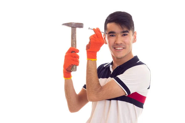 Homem de luvas laranja segurando martelo e unha — Fotografia de Stock