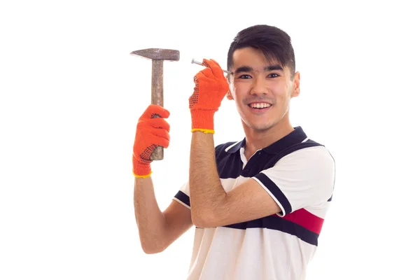 Man in orange gloves holding hammer and nail — Stock Photo, Image