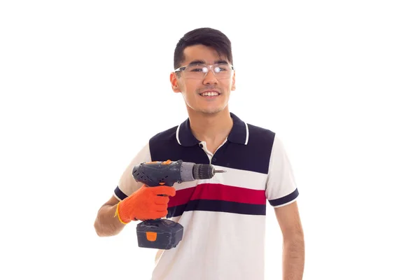 Eldiven ve gözlük elektrikli tornavida tutan genç adamla — Stok fotoğraf