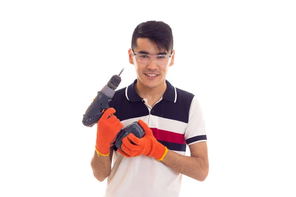 Jonge man met handschoenen en bril houden van elektrische schroevendraaier — Stockfoto