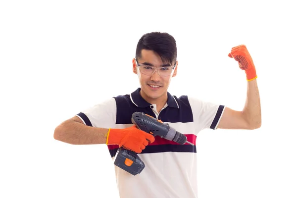 Jonge man met handschoenen en bril houden van elektrische schroevendraaier — Stockfoto