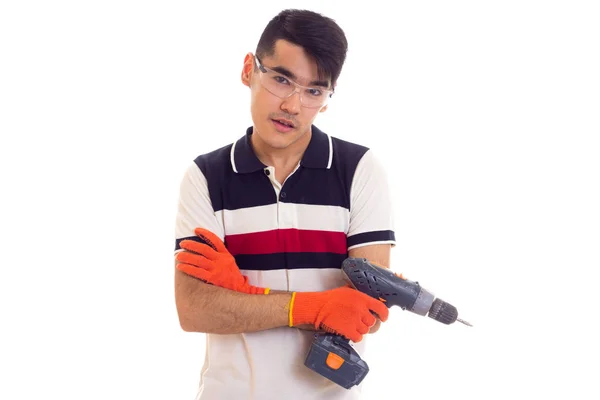 Молодий чоловік з рукавичками і окулярами тримає електричну викрутку — стокове фото