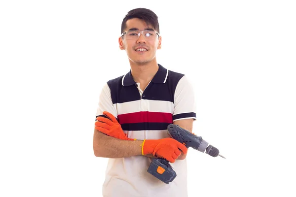 Jonge man met handschoenen en bril houden van elektrische schroevendraaier — Stockfoto