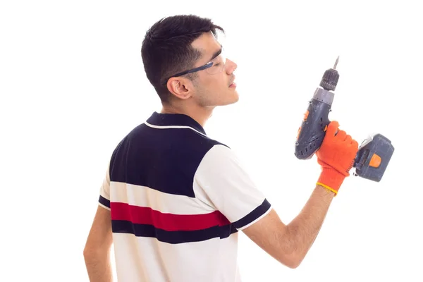 Junger Mann mit Handschuhen und Brille hält Elektroschrauber in der Hand — Stockfoto