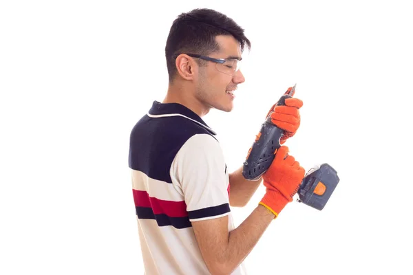 Молодий чоловік з рукавичками і окулярами тримає електричну викрутку — стокове фото