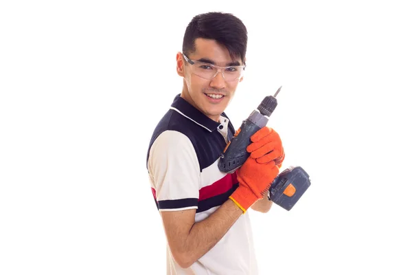 Młody człowiek z rękawice i okulary gospodarstwa Wkrętak elektryczny — Zdjęcie stockowe
