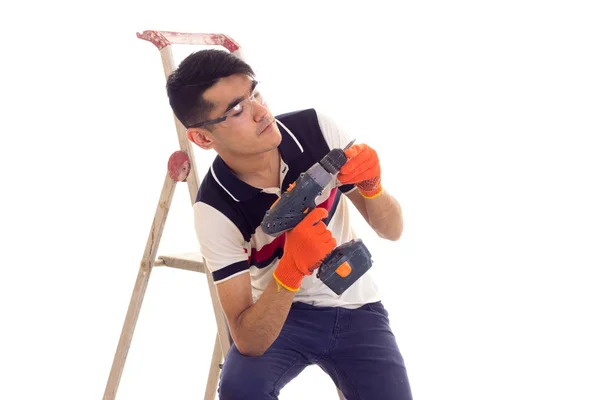 Jovem segurando chave de fenda elétrica e sentado no livro — Fotografia de Stock