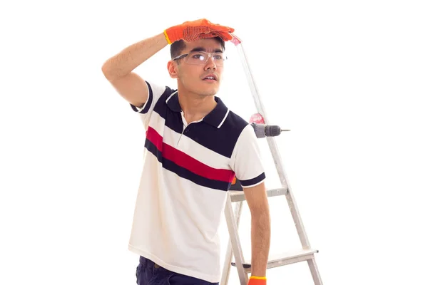 Young man with electric screwdriver and ledder — Stock Photo, Image