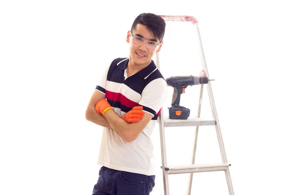 Young man with electric screwdriver and ledder — Stock Photo, Image