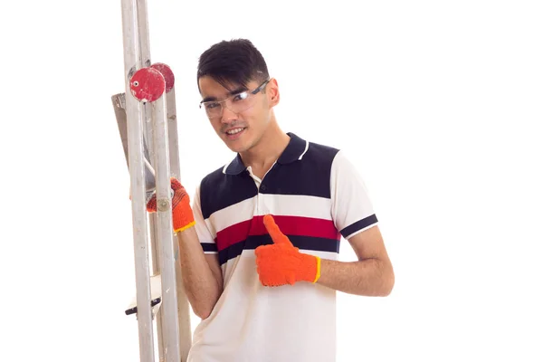 Young man in gloves and glasses holding a ledder — Stock Photo, Image