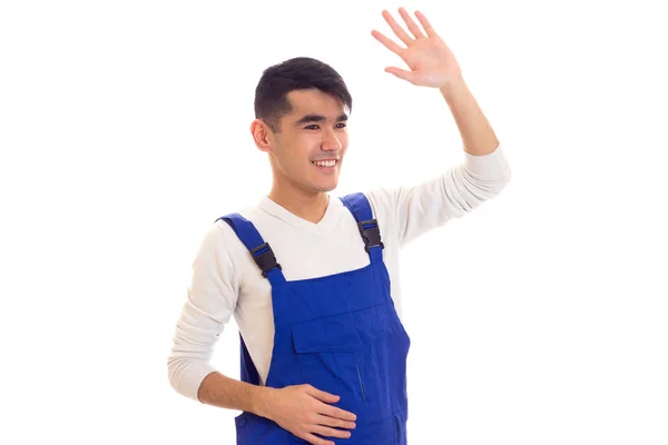 Young man in blue overall waving — Stock Photo, Image