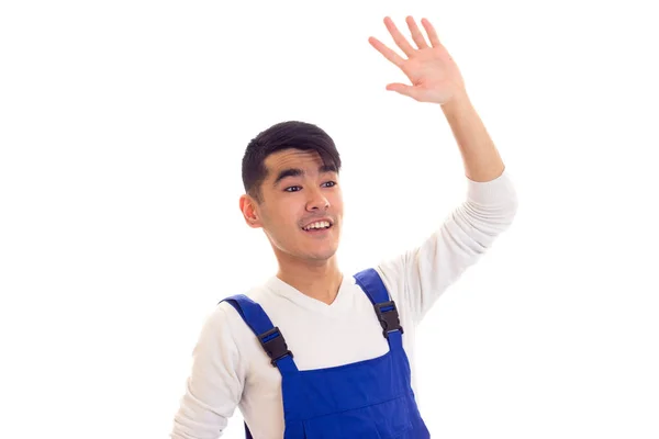 Young man in blue overall waving — Stock Photo, Image