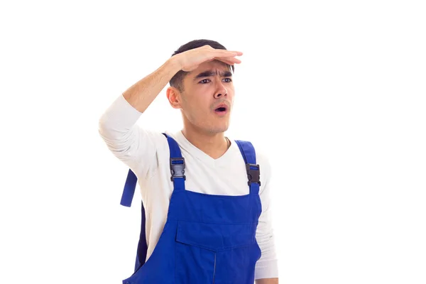 Young man in blue overall looking in a distance — Stock Photo, Image