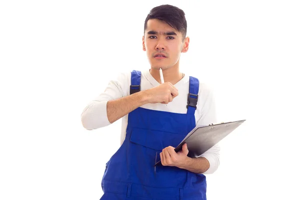 Mladý muž v modré celkově drží pero a složku — Stock fotografie