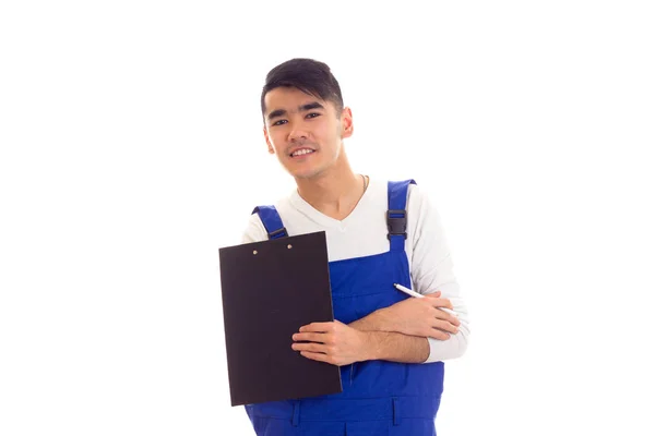 Mladý muž v modré celkově drží pero a složku — Stock fotografie