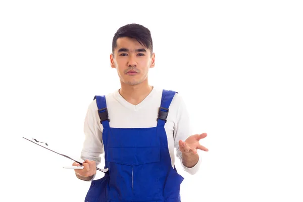 Young man in blue overall holding pen and folder — Stock Photo, Image