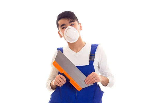Homem de azul em geral com respirador segurando espátula — Fotografia de Stock