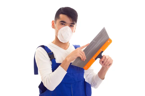 Mann in blauem Overall mit Atemschutzmaske mit Spatel — Stockfoto
