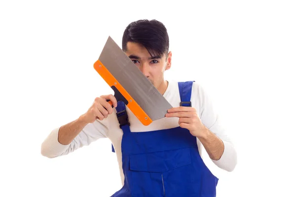 Man in blue overall holding spatula — Stock Photo, Image