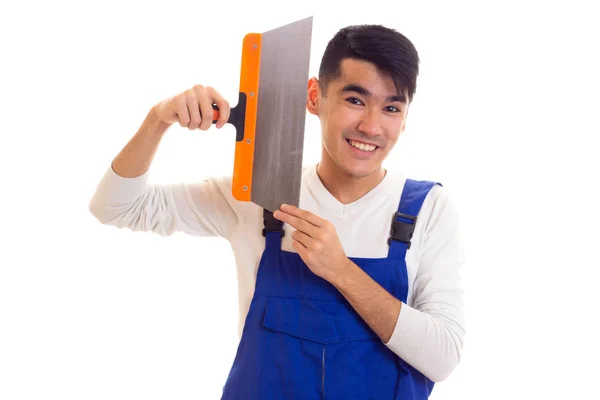 Man in blue overall holding spatula — Stock Photo, Image