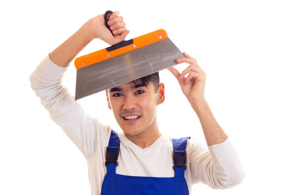 Man in blue overall holding spatula — Stock Photo, Image