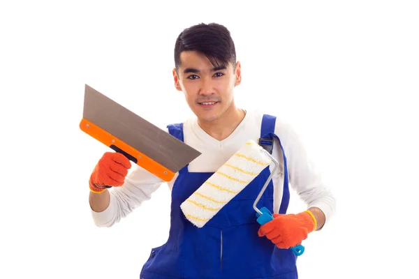 Man in blue overall with gloves holding spatula and roll — Stock Photo, Image