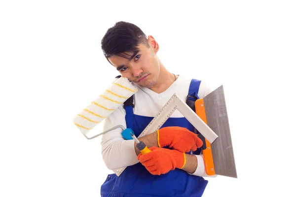 Uomo in generale con guanti con spatola, rotolo, righello e cacciavite — Foto Stock