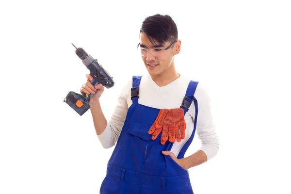 Man in overall met handschoenen en bril houden van elektrische schroevendraaier — Stockfoto