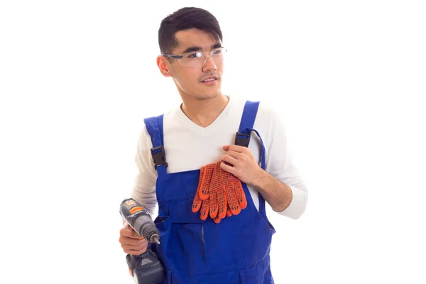 Man in overall met handschoenen en bril houden van elektrische schroevendraaier — Stockfoto