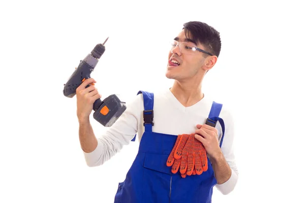 Man in overall met handschoenen en bril houden van elektrische schroevendraaier — Stockfoto