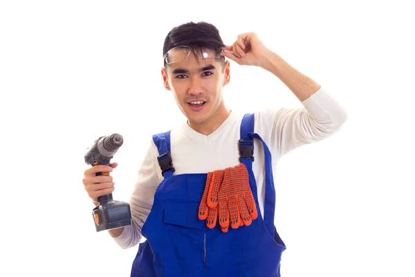 Man in overall met handschoenen en bril houden van elektrische schroevendraaier — Stockfoto