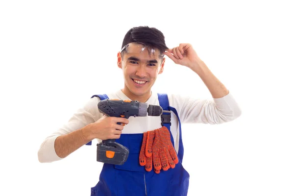 Man in overall met handschoenen en bril houden van elektrische schroevendraaier — Stockfoto