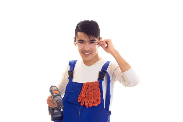 Man in overall met handschoenen en bril houden van elektrische schroevendraaier — Stockfoto