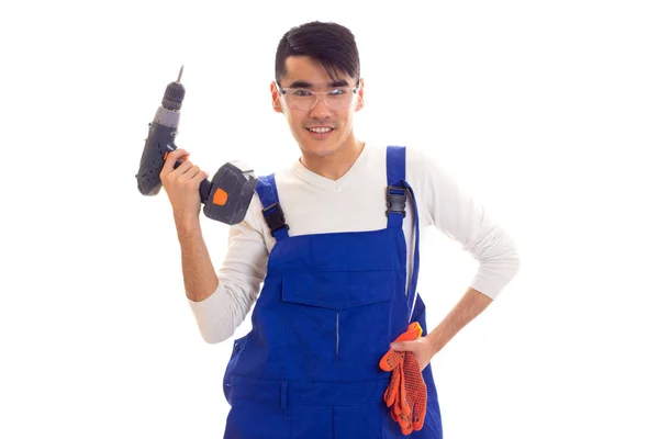 Man in overall met handschoenen en bril houden van elektrische schroevendraaier — Stockfoto