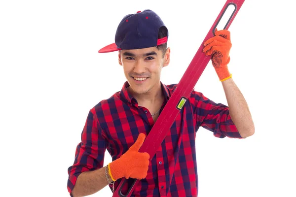 Young man in gloves and snapback holding level — Stock Photo, Image