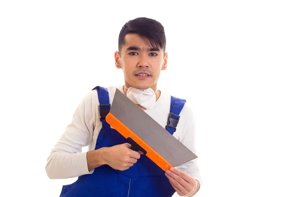 Man in blue overall with respirator holding spatula Stock Image