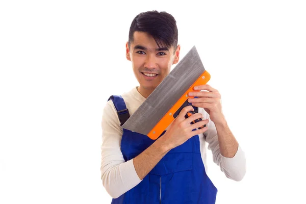 Man in blue overall holding spatula Stock Picture