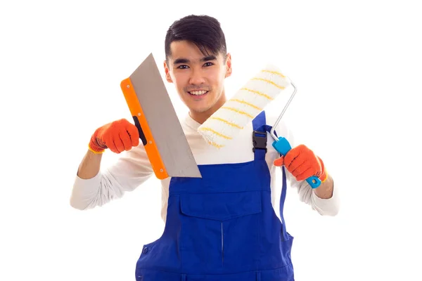 Man in blue overall with gloves holding spatula and roll Stock Photo