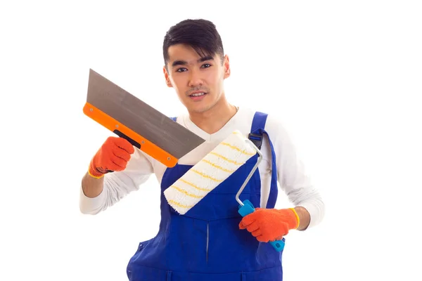 Man in blue overall with gloves holding spatula and roll Royalty Free Stock Photos