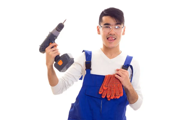 Man in overall with gloves and glasses holding electric screwdriver Royalty Free Stock Images