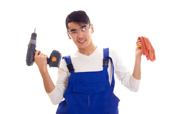 Man in overall with gloves and glasses holding electric screwdriver Stock Image