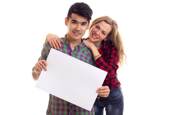 Young couple in plaid shirts holding placard — Stock Photo, Image