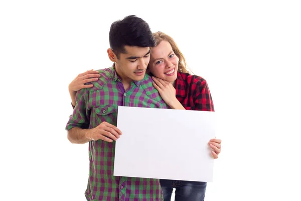 Young couple in plaid shirts holding placard — Stock Photo, Image