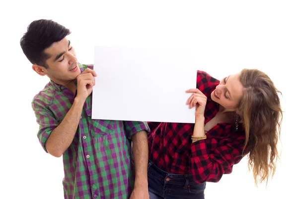 Young couple in plaid shirts holding placard — Stock Photo, Image