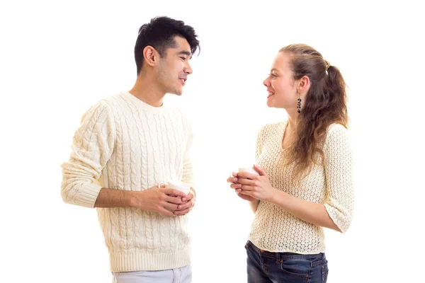 Jovem casal segurando copos e falando — Fotografia de Stock