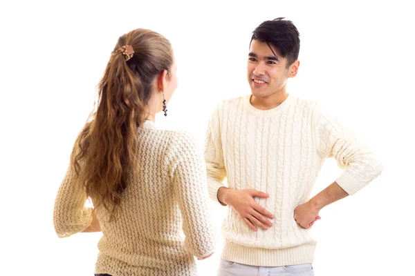 Молодая пара в белых свитерах разговаривает — стоковое фото